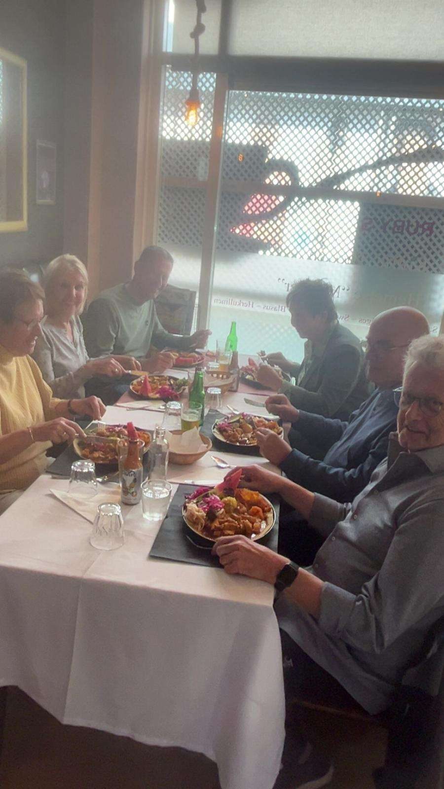 Gasten aan tafel in het restaurant van RUBY'S, met borden vol Surinaams eten